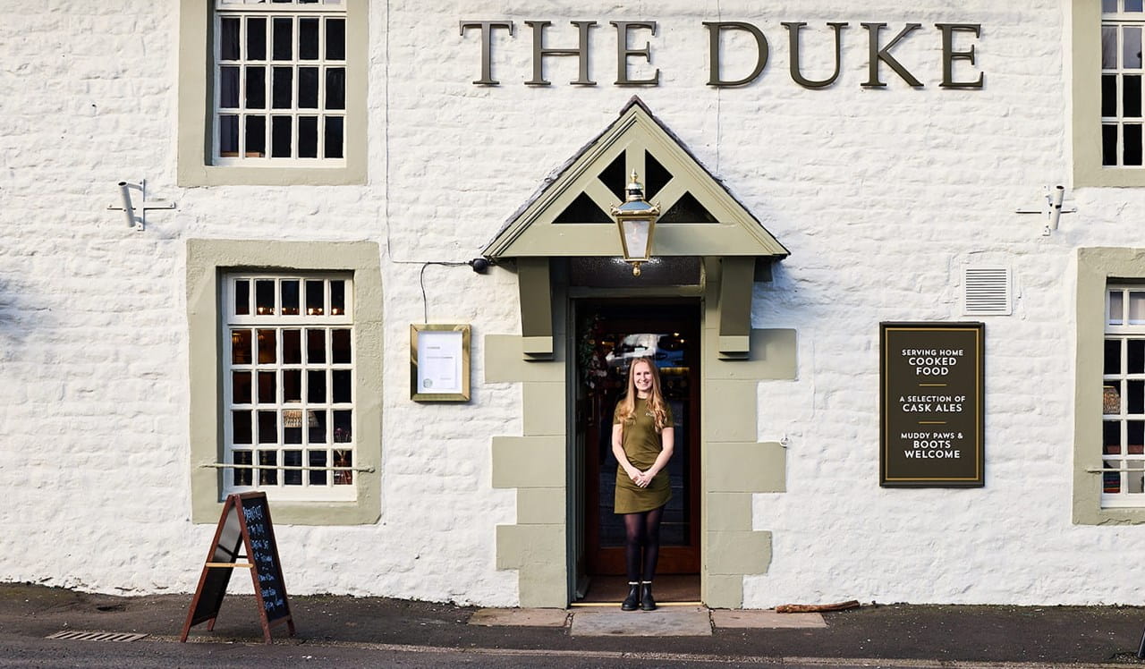 Woman standing outside her pub